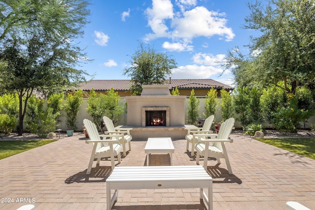 view of patio with exterior fireplace