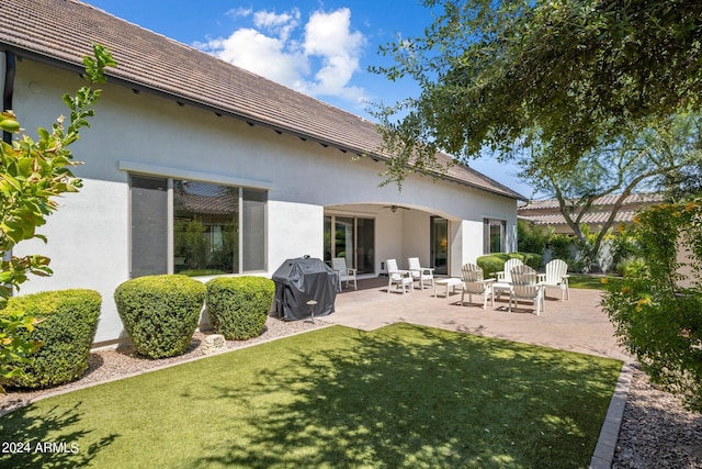 back of property with a lawn and a patio area