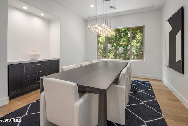 dining space featuring an inviting chandelier and light hardwood / wood-style floors