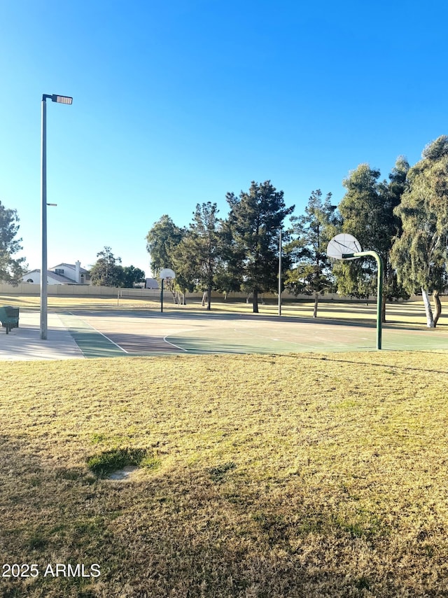 view of basketball court with a yard