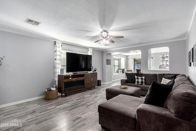 living room with ceiling fan, light hardwood / wood-style floors, and ornamental molding