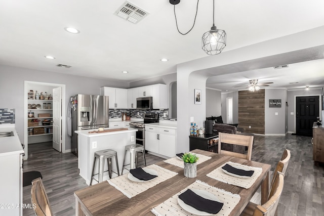 dining room with ceiling fan and dark hardwood / wood-style floors