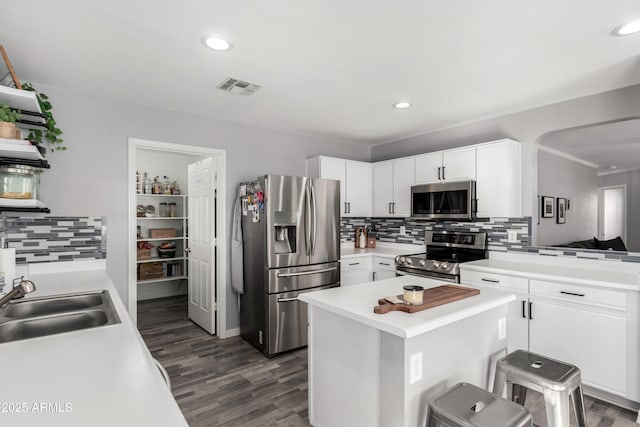 kitchen featuring white cabinetry, sink, dark wood-type flooring, a breakfast bar, and appliances with stainless steel finishes