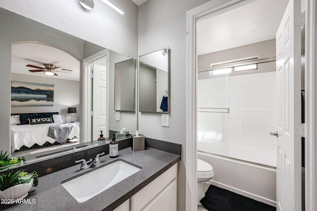 full bathroom with toilet, ceiling fan, vanity, and bath / shower combo with glass door