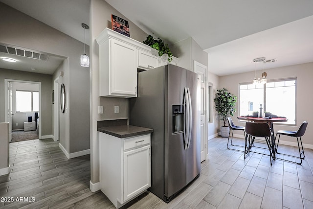 kitchen featuring white cabinetry, plenty of natural light, lofted ceiling, and stainless steel refrigerator with ice dispenser