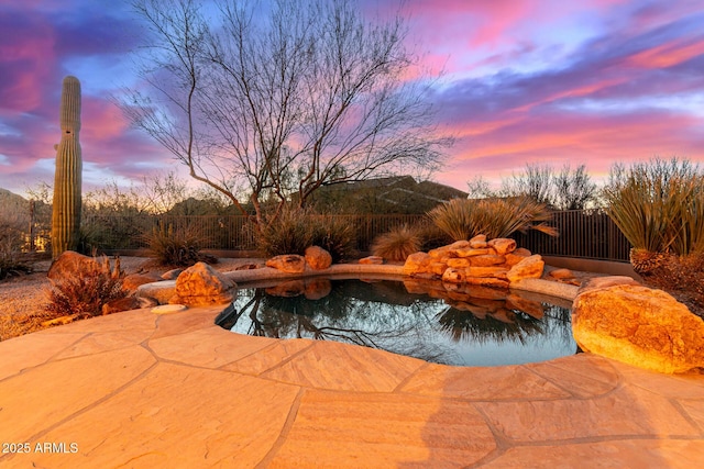 pool at dusk with a patio