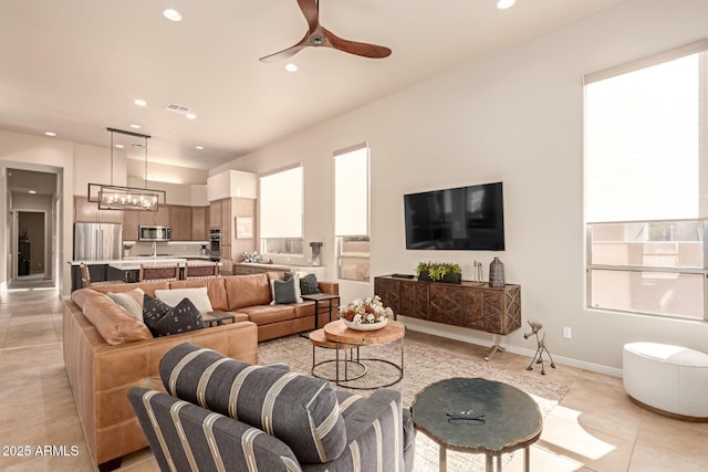 tiled living room featuring ceiling fan with notable chandelier