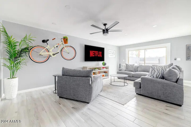 living room with light hardwood / wood-style flooring and ceiling fan