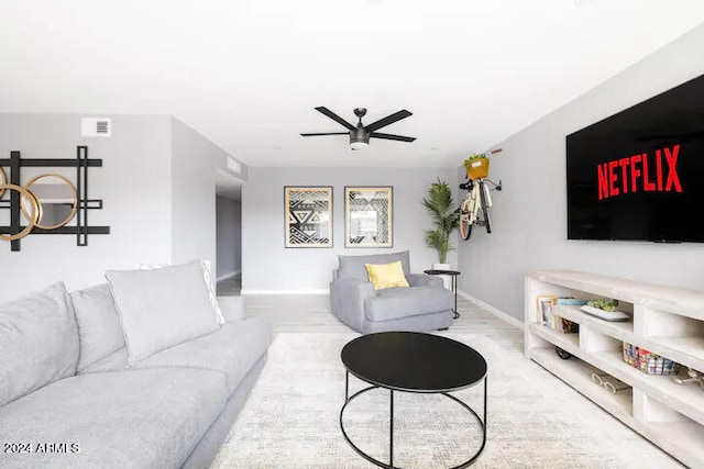 living room featuring light hardwood / wood-style floors and ceiling fan