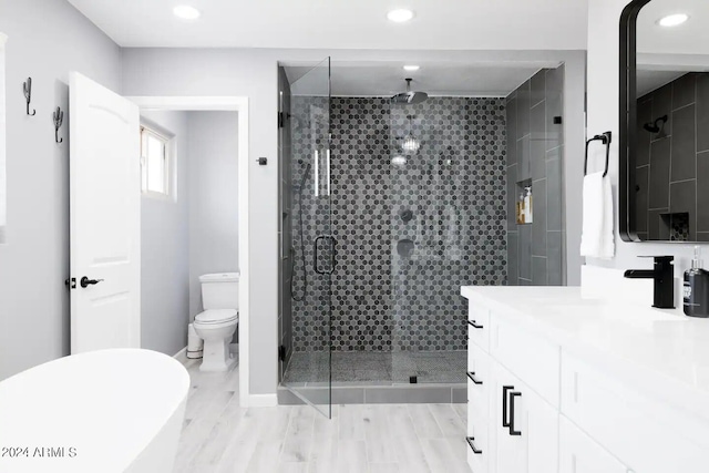 bathroom featuring hardwood / wood-style flooring, vanity, toilet, and a shower with shower door