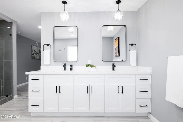 bathroom with vanity, a shower with shower door, and hardwood / wood-style flooring