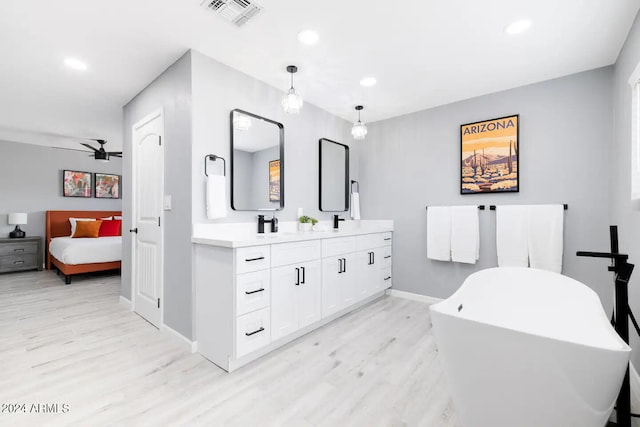 bathroom with a tub, ceiling fan, vanity, and wood-type flooring