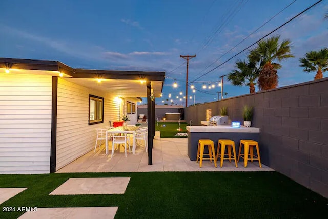 patio terrace at dusk featuring a bar