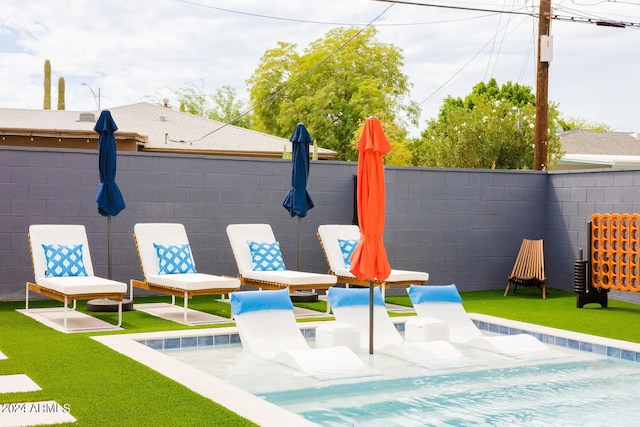 view of swimming pool with a yard