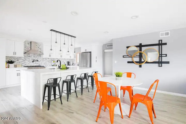 dining room with light hardwood / wood-style flooring and sink