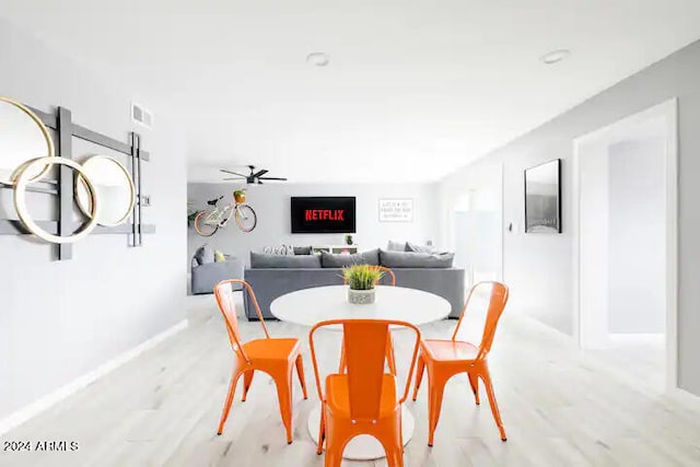 dining space with ceiling fan and light hardwood / wood-style flooring