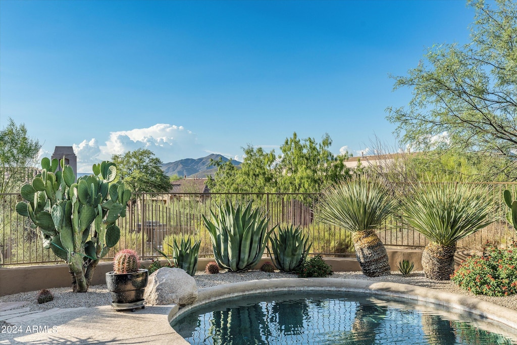 view of swimming pool with a fenced backyard, a mountain view, and a fenced in pool