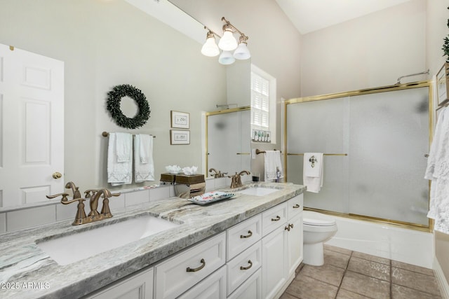 full bath with a sink, tile patterned floors, toilet, and double vanity