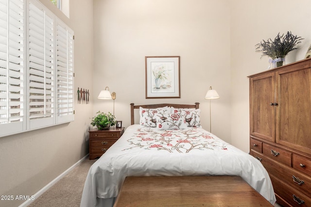 bedroom featuring carpet flooring, baseboards, and a towering ceiling