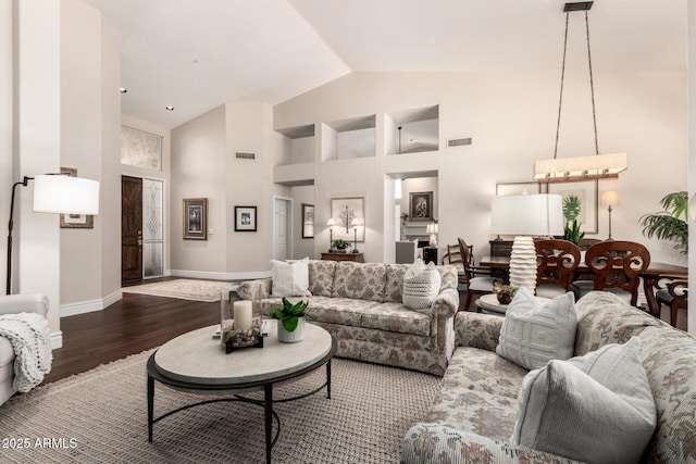 living room featuring visible vents, baseboards, dark wood-style floors, and high vaulted ceiling