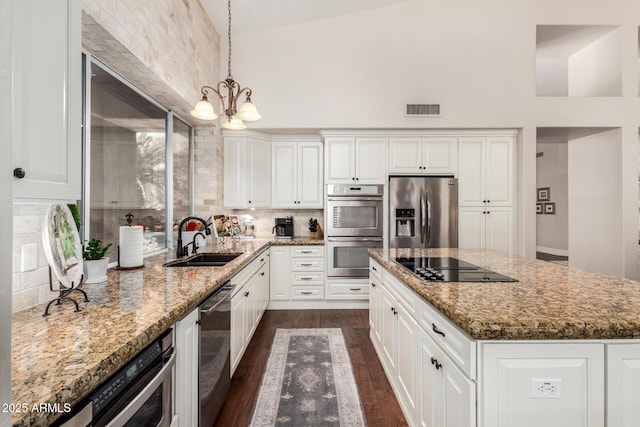 kitchen with visible vents, dark wood finished floors, a sink, an inviting chandelier, and stainless steel appliances