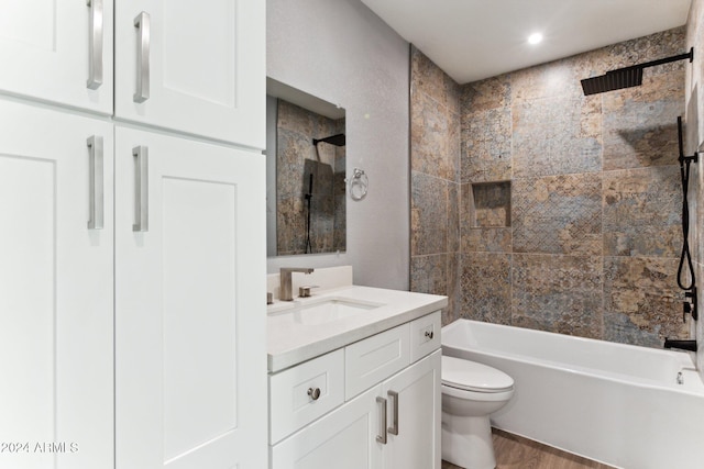 full bathroom with hardwood / wood-style floors, vanity, toilet, and tiled shower / bath