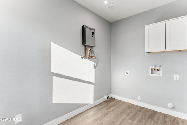 laundry area with cabinets, hookup for an electric dryer, hookup for a gas dryer, light hardwood / wood-style flooring, and hookup for a washing machine