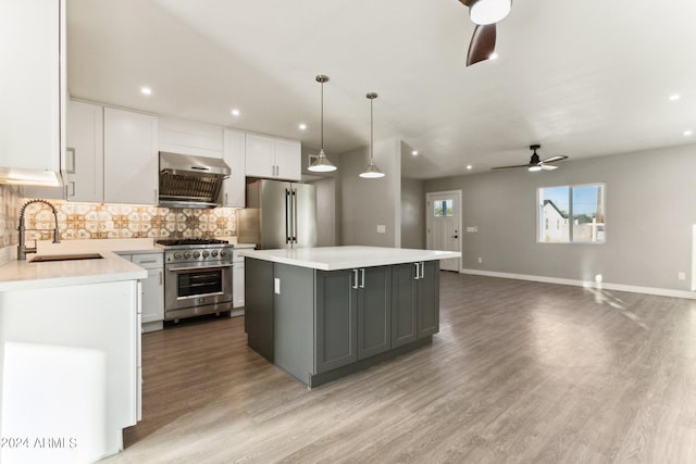 kitchen featuring stainless steel appliances, ceiling fan, sink, white cabinetry, and a kitchen island