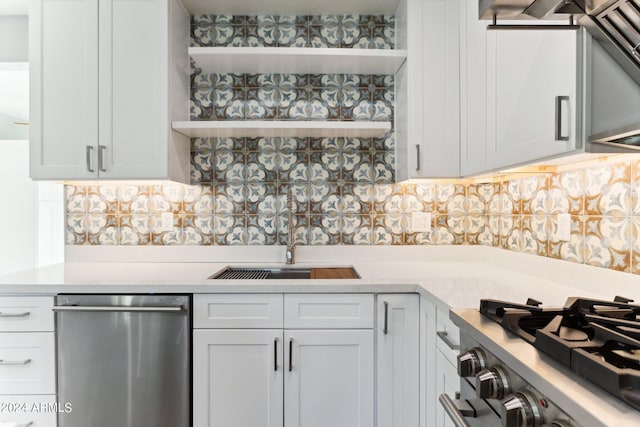 kitchen featuring decorative backsplash, sink, white cabinets, and appliances with stainless steel finishes