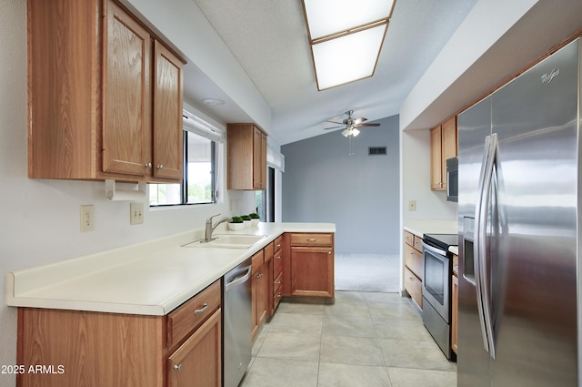 kitchen featuring ceiling fan, sink, kitchen peninsula, lofted ceiling, and appliances with stainless steel finishes