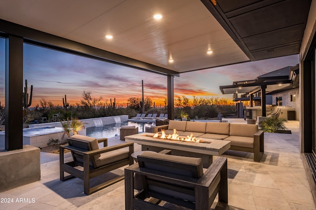 patio terrace at dusk with an outdoor kitchen and an outdoor living space with a fire pit