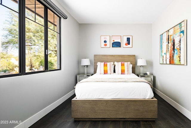 bedroom with dark hardwood / wood-style flooring and multiple windows