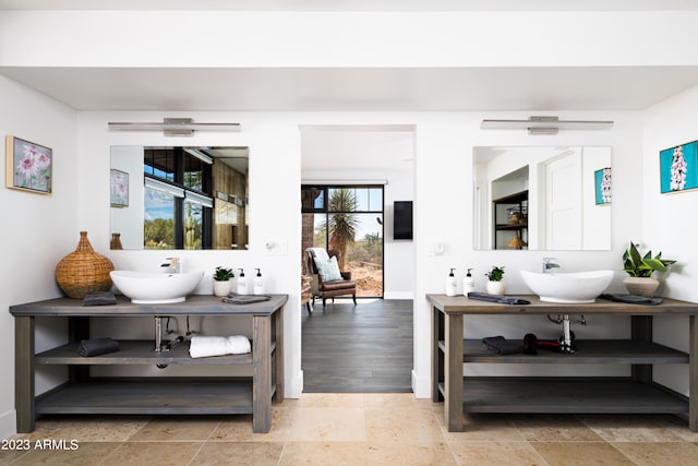 living room featuring sink, light hardwood / wood-style floors, and a healthy amount of sunlight