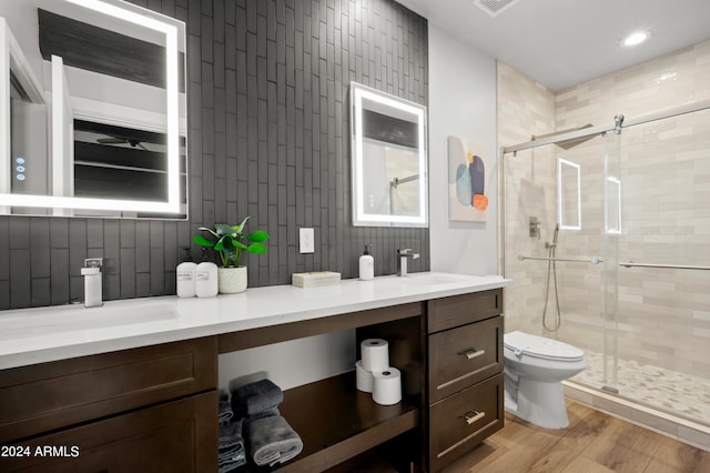 bathroom with tile walls, toilet, an enclosed shower, wood-type flooring, and vanity