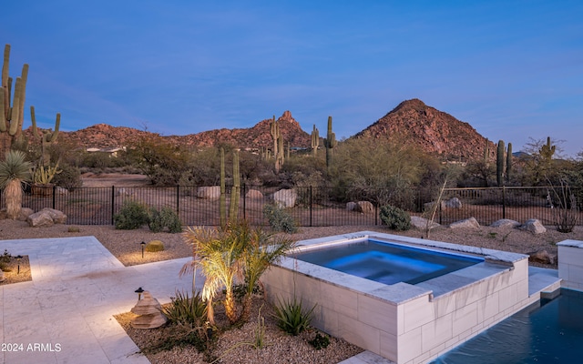 view of swimming pool with an in ground hot tub and a mountain view