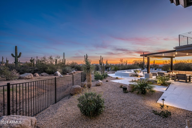 yard at dusk featuring outdoor lounge area and a patio area