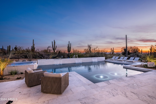 pool at dusk featuring a hot tub and a patio area