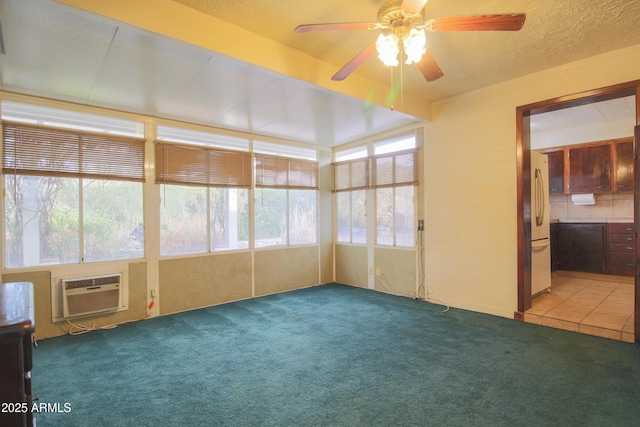 unfurnished sunroom featuring a wall unit AC and ceiling fan