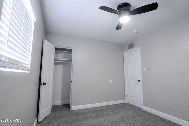 unfurnished bedroom featuring a closet, ceiling fan, and dark carpet