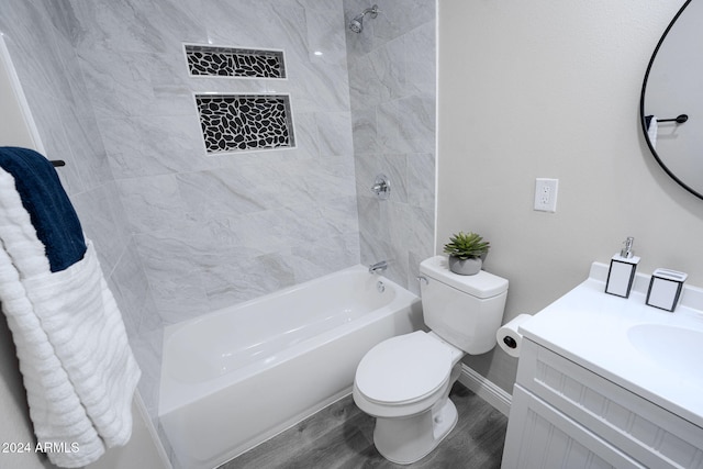 full bathroom featuring tiled shower / bath, vanity, wood-type flooring, and toilet