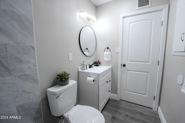 bathroom featuring vanity, wood-type flooring, and toilet