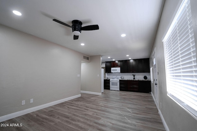 kitchen with decorative backsplash, dark brown cabinets, ceiling fan, light wood-type flooring, and white appliances