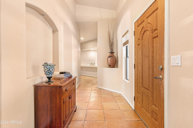 tiled foyer entrance featuring vaulted ceiling