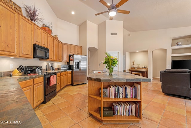 kitchen featuring a center island with sink, black appliances, ceiling fan, and high vaulted ceiling