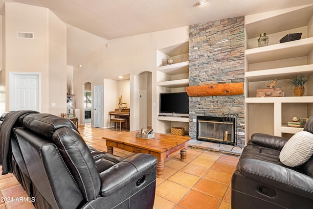 tiled living room featuring built in features, a textured ceiling, high vaulted ceiling, and a fireplace