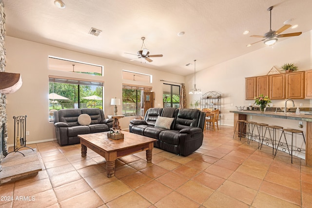 living room featuring high vaulted ceiling, ceiling fan, light tile patterned floors, and sink