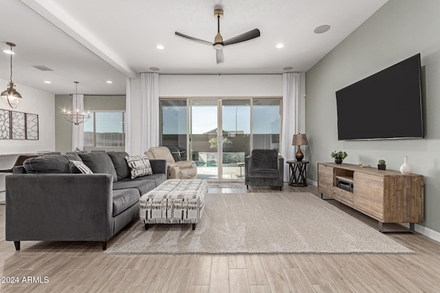 living room featuring ceiling fan with notable chandelier