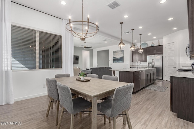 dining space with sink and an inviting chandelier