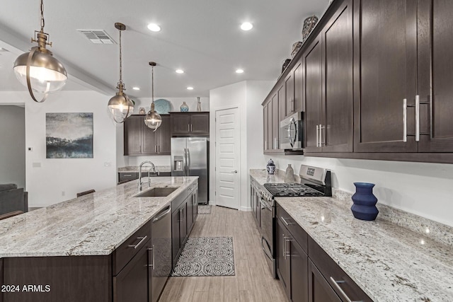 kitchen featuring decorative light fixtures, stainless steel appliances, a spacious island, and sink