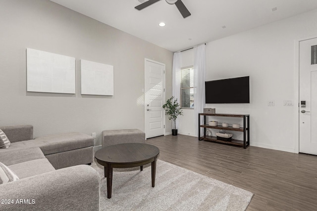 living room with ceiling fan and dark hardwood / wood-style flooring